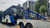 Setidaknya butuh waktu 45 menit untuk melakukan evakuasi bus TransJakarta tersebut. Usai kendaraan dinyatakan aman dari puing-puing beton separator, petugas kemudian memasang rantai derek ke bagian depan bus TransJakarta untuk segera dievakuasi. (Foto: Yogi Ernes/detikcom) 