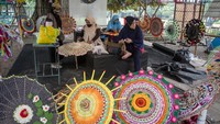 Pengrajin membuat payung rajut pada Festival Payung 2021 di Taman Balekambang, Solo, Jawa Tengah.