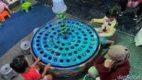 Orang tua mendampingi anak-anaknya bermain.