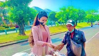 Saat memborong dagangan, Heni langsung menyambangi pedagang tersebut satu persatu. Seperti saat memborong pedagang ubi cilembu, Heni Tania turun langsung ke trotoar untuk membungkus ubi-ubi yang dijajakan. Foto: Instagram/henitania