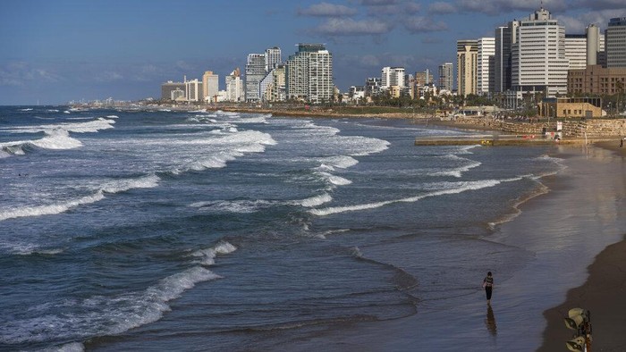 Geser Paris, Tel Aviv Jadi Kota Termahal di Dunia A woman walks on the Tel Aviv's Mediterranean Sea beachfront, Israel, Thursday, Dec. 2, 2021. Residents of Israel's seaside metropolis Tel Aviv have for years complained of how expensive it is, with living costs taking a chunk out of their paychecks. A report released Wednesday, Dec. 1, 2021, by the Economist Intelligence Unit, a research group linked to the Economist magazine, said Tel Aviv has emerged as the most expensive city to live in. (AP Photo/Oded Balilty)