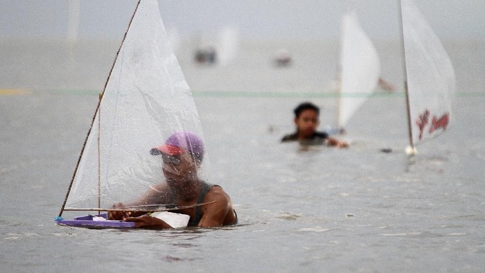 Peserta mempersiapkan perahu saat mengikuti lomba balap perahu layar mini di Pantai Kenjeran, Bulak Cumpat, Surabaya, Jawa Timur, Sabtu (4/12/2021). Kegiatan yang diikuti 102 peserta tersebut guna menarik wisatawan sekaligus penyaluran hobi balap perahu layar mini bagi masyarakat nelayan di sekitar Pantai Kenjeran. ANTARA FOTO/Moch Asim/rwa.