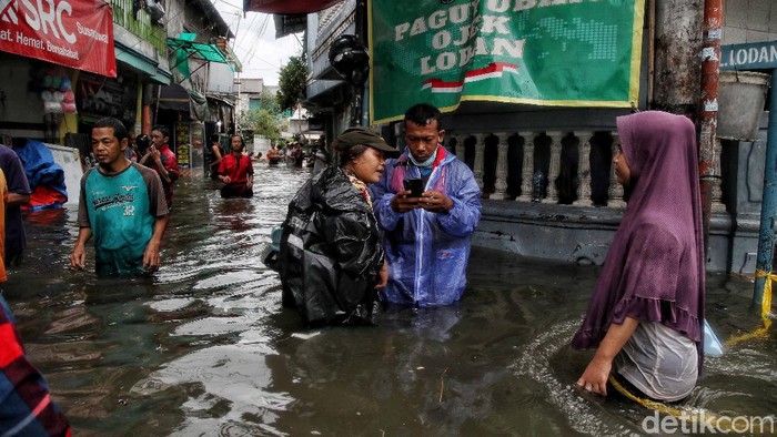 Sejumlah warga beraktivitas di kawasan yang terendam banjir rob Kampung Japat, Lodan Ancol, Jakarta Utara, Sabtu (4/12). Menurut keterangan warga, banjir rob ini terjadi sejak pukul 8 pagi.