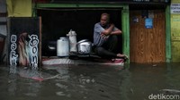 Mereka terus berjualan di tengah banjir rob. 