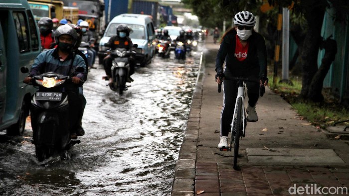 Waspada, Jalan RE Martadinata Ancol Terendam Banjir Rob Petugas gabungan mengatur lalu lintas di kawasan yang terendam air rob di Jalan RE Martadinata, Ancol, Nakarta Utara, Sabtu (4/12/2021) pagi. Banjir rob tersebut terjadi sejak Jumat (2/12).