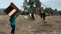 Tampak sejumlah warga membawa barang-barang yang dapat diselamatkan usai rumah mereka terdampak erupsi Gunung Semeru pada Sabtu (4/12) lalu.