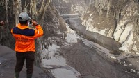 Relawan memotret jembatan Besuk Koboan atau biasa disebut Gladak Perak yang putus di Candipuro, Lumajang, Jawa Timur, Minggu (5/12/2021).