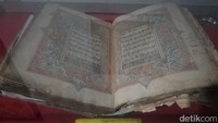 Sebuah Al-Quran tersimpan rapi di dalam etalase kedap udara. Sepintas huruf dan ukiran kaligrafinya tidak jauh berbeda dengan Al-Quran pada umumnya. Namun setelah diperhatikan dari dekat, Al-Quran tersebut ternyata buah hasil tulisan tangan bukan dari cetakan pabrik.