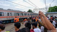 Sejumlah warga menyaksikan proses perbaikan KRL yang anjlok di dekat Stasiun Sudimara, Tangerang Selatan.