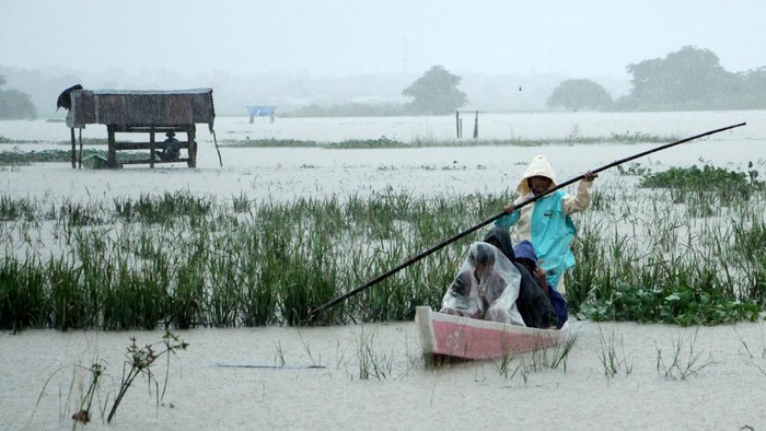 Sejumlah murid naik perahu saat melintasi area persawahan yang terendam banjir di Kelurahan Tamangapa, Makassar, Sulawesi Selatan, Senin (6/12/2021). Sejumlah murid setempat mengaku terpaksa menggunakan perahu untuk pergi belajar ke sekolahnya akibat akses jalan di daerah itu terendam banjir. ANTARA FOTO/Arnas Padda/yu/wsj.