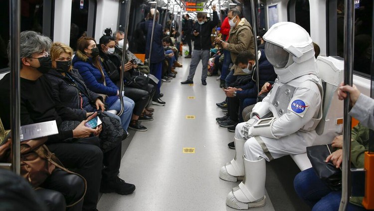 Seorang pria berpakaian astronot terlihat di sejumlah ruang publik. Ternyata ia tengah melakukan bagian dari kampanye untuk mempromosikan Pameran Luar Angkasa NASA, di Istanbul, Turki, Sabtu, 4 Desember 2021. (AP Photo/Emrah Gurel)