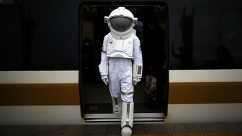 Seorang pria berpakaian astronaut turun dari kereta di stasiun MRT saat ia melakukan perjalanan di Istanbul, Turki, Sabtu, (4/12).