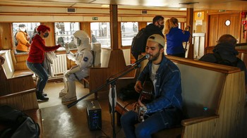Seorang pria berpakaian astronaut melintasi Bosphorus dengan kapal feri. Pameran ini akan menampilkan modul khusus dari luar angkasa dan puluhan instrumen berteknologi tinggi.