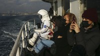 Seorang pria berpakaian astronot terlihat di sejumlah ruang publik. Ternyata ia tengah melakukan bagian dari kampanye untuk mempromosikan Pameran Luar Angkasa NASA, di Istanbul, Turki, Sabtu, 4 Desember 2021. (AP Photo/Emrah Gurel)