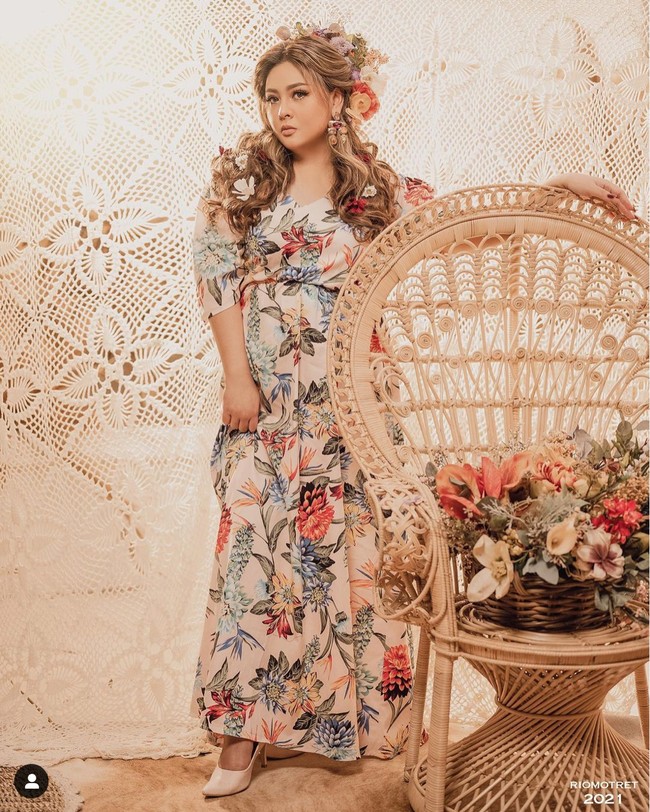 Mengenakan gaun bermotif bunga dan hiasan kepala yang juga dipenuhi dengan berbagai macam bunga membuat penampilan Audy terlihat semakin anggun. Penampilannya itu dipercantik dengan aksesori berupa anting berwarna merah keemasan dan kuku yang telah diberi kuteks berwarna merah. Foto: Instagram