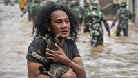 Seorang laki-laki membawa kucing saat banjir di Perumahan Bhayangkara Ranjok, Kecamatan Gunungsari, Lombok Barat, NTB.