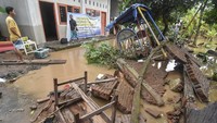 Warga memerhatikan tembok bangunan yang roboh diterjang banjir di Desa Sesela, Kecamatan Gunungsari, Lombok Barat, NTB.