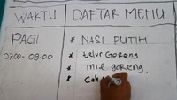 Seorang relawan menulis menu makanan bagi para pengungsi.