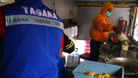Dua relawan memasak makanan untuk dibagikan kepada pengungsi.