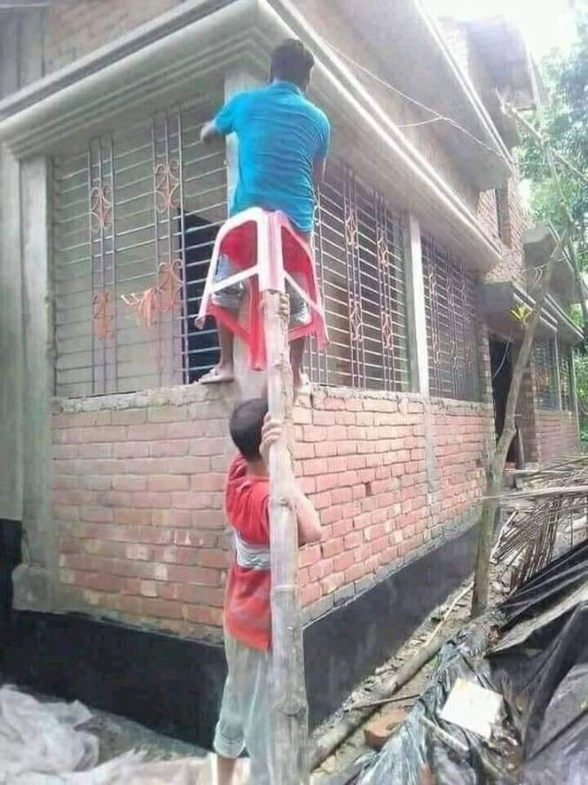 Kalau ada yang sulit kenapa harus cari yang mudah? Padahal bisa menggunakan tangga, tapi kedua pria ini malah memilih cara ekstrem yang satu ini. Benar-benar bikin geleng-geleng kepala. Foto: twitter.com/DuniaKuli