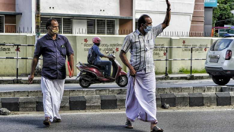 Kochi, India - May 2020: People with facemasks crossing the street during the confinement due to the Covid-19 pandemic on May 22, 2020 in Kochi, Kerala, India.
