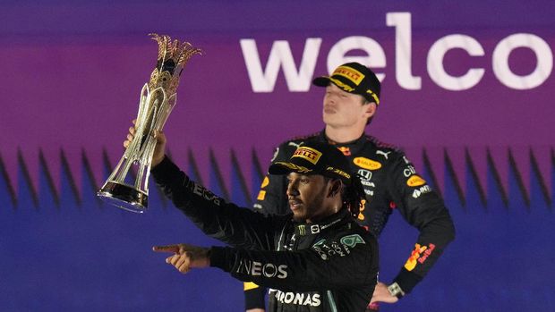 Mercedes driver Lewis Hamilton of Britain celebrates winning the Formula One Saudi Arabian Grand Prix in front of the second placed Red Bull driver Max Verstappen of the Netherlands, in Jiddah, Sunday, Dec. 5, 2021. (AP Photo/Hassan Ammar)