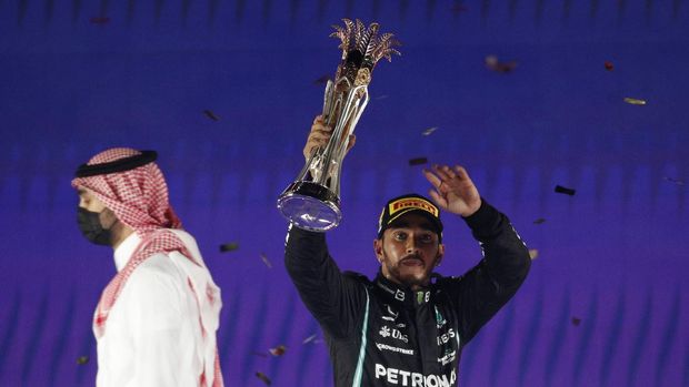Formula One F1- Saudi Arabian Grand Prix - Jeddah Corniche Circuit, Jeddah, Saudi Arabia - December 5, 2021 Mercedes' Lewis Hamilton celebrates with the trophy on the podium after winning the race REUTERS/Hamad I Mohammed