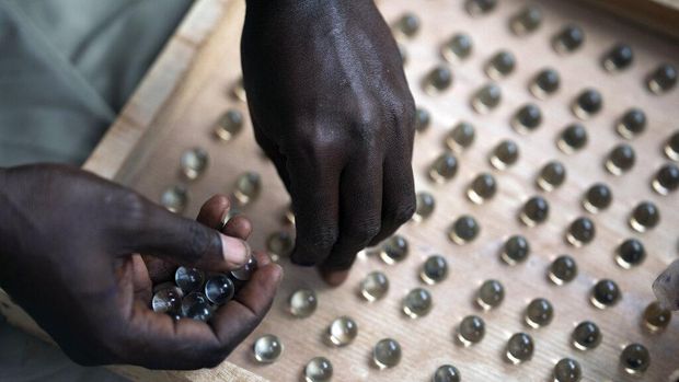 Pekerja pemilu menyiapkan drum suara di sebuah tempat pemungutan suara di Bakau, Gambia, Sabtu, 4 Desember 2021. Warga Gambia memberikan suara dalam pemilu bersejarah yang untuk pertama kalinya tidak akan ada mantan diktator Yahya Jammeh, yang memerintah selama 22 tahun, di suara. (Foto AP/Leo Correa)