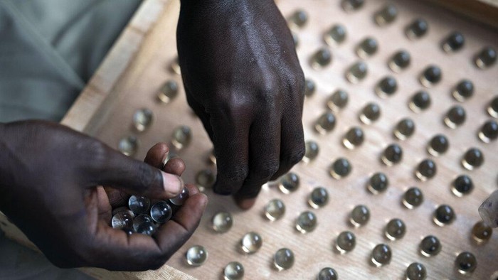 Negara Gambia Pakai Kelereng untuk Pemilihan Presiden Pekerja pemilu menyiapkan drum suara di sebuah tempat pemungutan suara di Bakau, Gambia, Sabtu, 4 Desember 2021. Warga Gambia memberikan suara dalam pemilu bersejarah yang untuk pertama kalinya tidak akan ada mantan diktator Yahya Jammeh, yang memerintah selama 22 tahun, di suara. (Foto AP/Leo Correa)