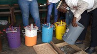 Seorang petugas pemilu menggunakan papan hitung untuk menghitung kelereng dari tempat pemungutan suara selama pemilihan presiden Gambia di Serrekunda, Gambia.