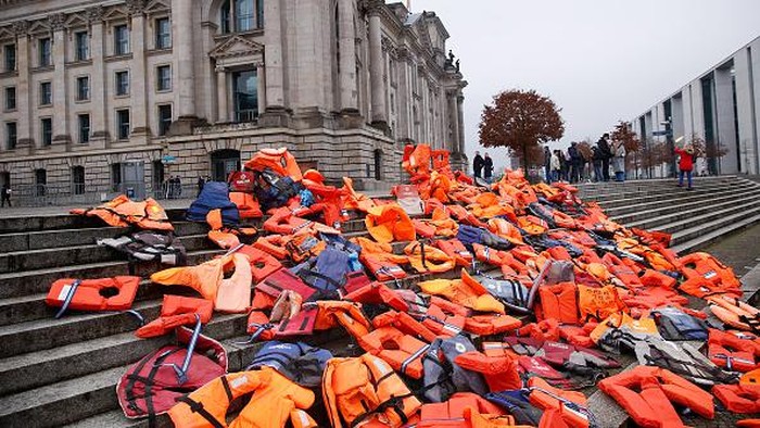 Ratusan Pelampung Terhampar di Jalanan Berlin, Ada Apa? BERLIN, GERMANY - DECEMBER 05: An installation created by activists next to the Reichstag using 300 life vests originally left behind by migrants on the Greek island of Lesbos on December 5, 2021 in Berlin, Germany. The activists, from the