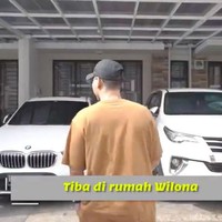 Pada bagian depan, terdapat garasi yang dapat memuat dua mobil. Ada dua mobil mewah yang diparkir, sebuah sedan BMW dan Toyota Fortuner yang sama-sama berwarna putih. (Foto: YouTube/Sibad Krisjiana)