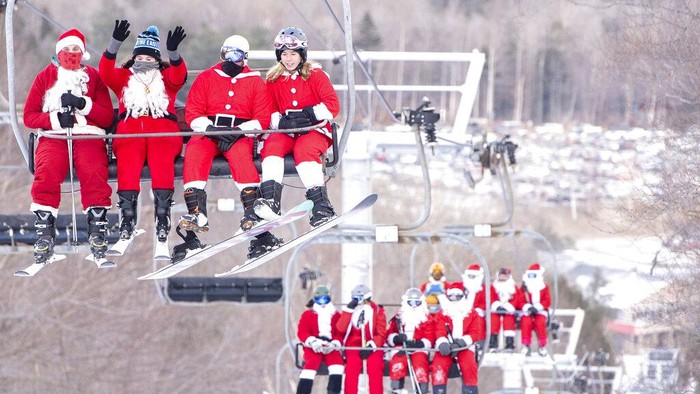 Pemain ski dan snowboarder bermain ski di lereng Minggu, 5 Desember 2021 di Resor Ski Sunday River di Newry, Maine. Keluarga Santa berkumpul untuk Hari Minggu Santa tahunan ke-21 yang mengumpulkan lebih dari $4600 untuk Dana Sungai. (Andree Kehn/Sun Journal via AP)