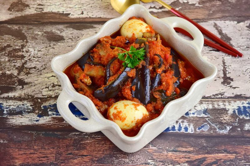 Indonesian Food, Terong Telur Balado, eggplant and egg with spicy chili sauce garnish with parsley.