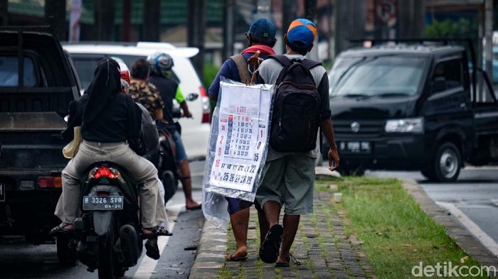 Memasuki bulan Desember 2021, kalender tahun 2022 mulai dijajakan. Pedagang menjajakan kalender 2022 di pasar hingga lampu merah.
