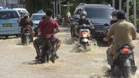 Sejumlah pengendara sepeda motor dan mobil melintasi jalur wisata Mataram-Senggigi yang terendam banjir di Desa Meninting, Kecamatan Batulayar, Lombok Barat, NTB, Selasa (7/12/2021). Jalan utama dari Kota Mataram menuju kawasan wisata Senggigi terendam banjir mencapai 1 meter akibat hujan deras dan luapan air sungai Meninting pada Senin (6/12). (ANTARA FOTO/Ahmad Subaidi).