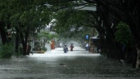 Warga melintas di Jalan Yusuf Bauty yang terendam banjir di Kelurahan Paccinongan, Kabupaten Gowa, Sulawesi Selatan, Selasa (7/12/2021). Sejumlah permukiman di daerah itu terendam banjir akibat hujan dengan intensitas tinggi beberapa hari terakhir sehingga sebagian warga mulai mengungsi. (ANTARA FOTO/Arnas Padda).