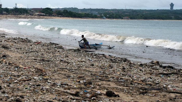 Sejumlah nelayan beraktivitas di tengah tumpukan sampah yang berserakan di Pantai Kedonganan, Badung, Bali, Selasa (7/12/2021). Cuaca ekstrem yang melanda Bali pada Senin (6/12/2021) tersebut menyebabkan sampah plastik, kayu, bambu dan kelapa terdampar di pesisir pantai akibat terbawa gelombang laut sehingga mencemari kawasan pariwisata itu. ANTARA FOTO/Nyoman Hendra Wibowo/foc.