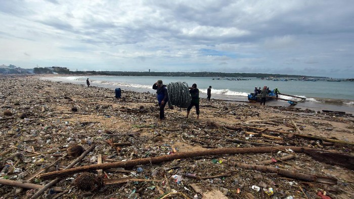 Cuaca Ekstrem di Bali Bikin Pantai Kedonganan Penuh Sampah Sejumlah nelayan beraktivitas di tengah tumpukan sampah yang berserakan di Pantai Kedonganan, Badung, Bali, Selasa (7/12/2021). Cuaca ekstrem yang melanda Bali pada Senin (6/12/2021) tersebut menyebabkan sampah plastik, kayu, bambu dan kelapa terdampar di pesisir pantai akibat terbawa gelombang laut sehingga mencemari kawasan pariwisata itu. ANTARA FOTO/Nyoman Hendra Wibowo/foc.