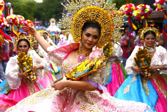 Antipolo City, Philippines - May 1, 2018: Parade participants in their colorful costumes march and dance in the street during the Sumakah Festival in Antipolo City.