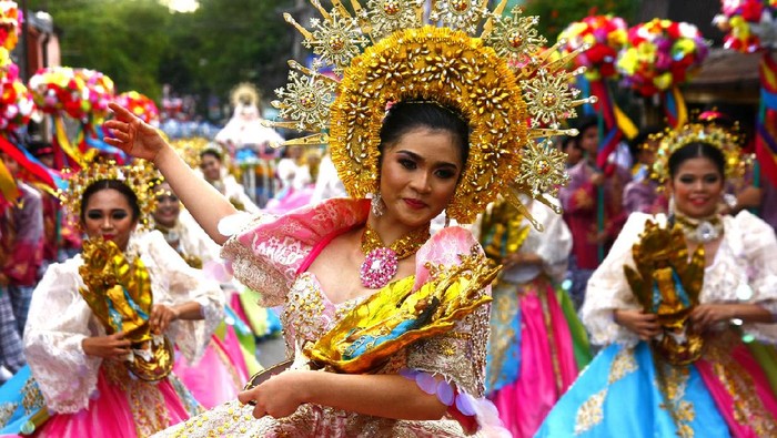 Antipolo City, Philippines - May 1, 2018: Parade participants in their colorful costumes march and dance in the street during the Sumakah Festival in Antipolo City.
