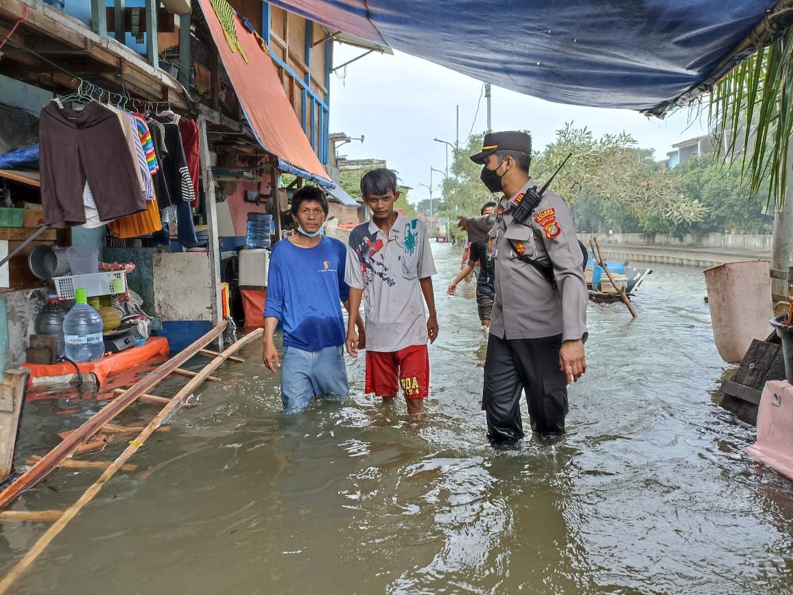 Kapolsek Kawasan Pelabuhan Sunda Kelapa AKP Seto Handoko berkeliling mengecek ketinggian air dan warga saat rob.