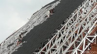 Tampak pekerja tengah memasang genting baja ringan atau biasa disebut genting metal.