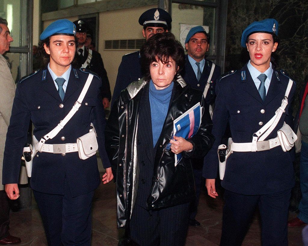 Maurizio Gucci's ex-wife Patrizia Reggiani Martinelli is escorted by police officers into Milan's court  in this November 3, 1998  photo,  during a hearing of  the trial  for the slaying of  the fashion scion. An appeals court in Milan Friday, March 17,2000, upheld her murder conviction,but shaved three years off her 29-year prison sentence.   (AP Photo/File,Luca Bruno)