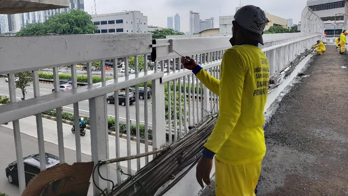 Petugas mengecat JPO Jl MT Haryono, Jakarta Timur.