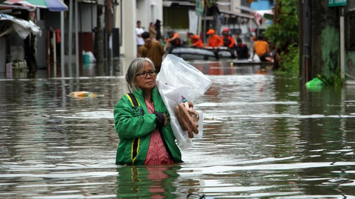 RATUSAN RUMAH TERENDAM BANJIR DI MAKASSAR Warga menerobos banjir di Kelurahan Batua, Makassar, Sulawesi Selatan, Selasa (7/12/2021). Ratusan rumah di daerah itu terendam banjir akibat curah hujan yang tinggi dan sebagian warga sudah mulai mengungsi. ANTARA FOTO/Arnas Padda/yu/foc.