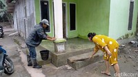 Khusnul Shoifa bersama suaminya terlihat membersihkan pekarangan rumahnya di Desa Sumber Wuluh.