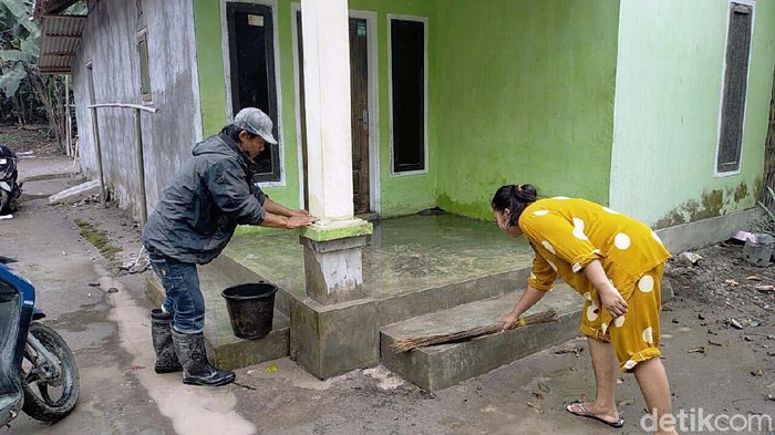 Warga pengungsi Semeru menyempatkan diri kembali ke rumahnya. Mereka mulai membersihkan rumah dari guyuran abu vulkanik.