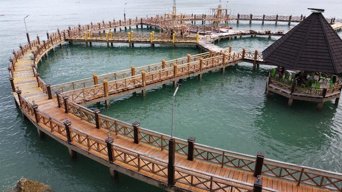Foto udara wisata Jembatan Lingkar Lapoili di Desa Wangi-wangi, Kecamatan Sampolawa, Buton Selatan, Sulawesi Tenggara, Senin (6/12/2021). Wisata Jembatan Lingkar Lapoili berhasil meraih juara 3 pada Anugerah Pesona Indonesia (API) Award 2021 kategori Destinasi Wisata Keatif yang pengembangannya memanfaatkan Dana Desa. ANTARA FOTO/Jojon/aww.
