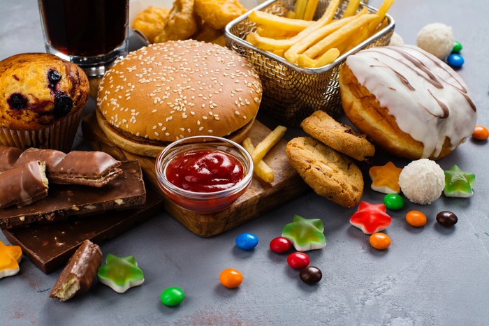 Assortment of unhealthy products thats bad for figure, skin, heart and teeth. Fast carbohydrates food. Space for text